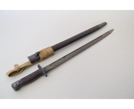 An English bayonet complete with scabbard and canvas belt loop, made by Wilkinson, 1907, 47cmL