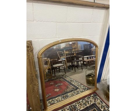 Modern arch top over mantel mirror set in a gilt frame