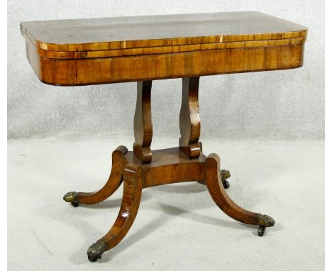 A Regency rosewood card table with foldover baize lined top on twin lyre shaped supports resting on platform base with quadru