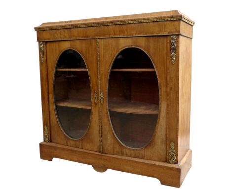A Victorian walnut veneered pier cabinet, gilt metal mounted, caddy top above two doors with oval glass, enclosing two shelve