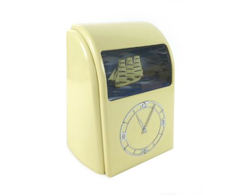 A Vitascope cream Bakelite-cased automaton clock, circa 1940s, electric-powered movement with chrome chapter ring below a Per