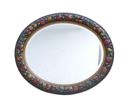 An oval Barbola mirror, with traditional fruit border, 79 by 67cm. 