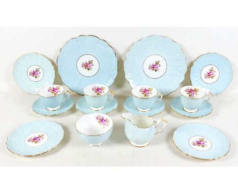 An Aynsley china part tea service, moulded leaf pattern in pale blue glaze centered by a painted spray of pink roses, gilt bo