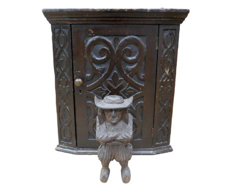 A carved oak spill holder in the form of a 17th century man, 9 by 6.5 by 32.5cm high, and a oak corner cabinet, with single s