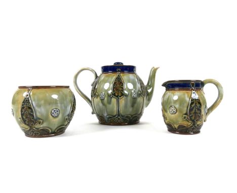 A Royal Doulton stoneware matched three piece tea service, circa 1900, decorated in Art Nouveau taste with stylised leaves an