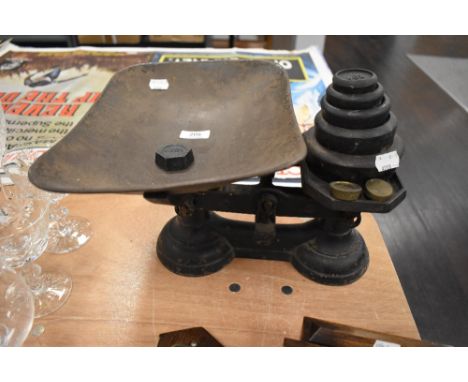 A set of cast iron kitchen balance scales with weight set