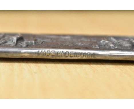 A 20th century white metal comb sheath decorated with musical scenes bearing a Danish mark
