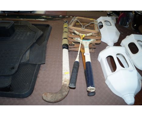 Two vintage tennis rackets; a badminton racket and a hockey stick