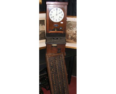 A British Time Recorder Co. Ltd. "National" clocking-in clock and card rack in oak case