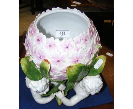 A decorative ceramic table centre of cherub and floral form