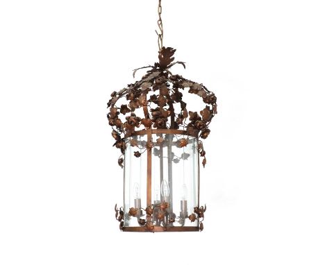 A French pressed metal lantern,of cylindrical shape in bronzed metal, the top entwined with flowering foliage over segmental 