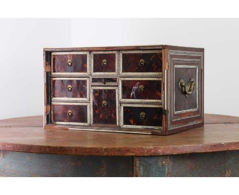 An Indo-Portuguese rosewood, tortoiseshell and ivory table cabinet,17th century, with a pair of panelled doors enclosing an a