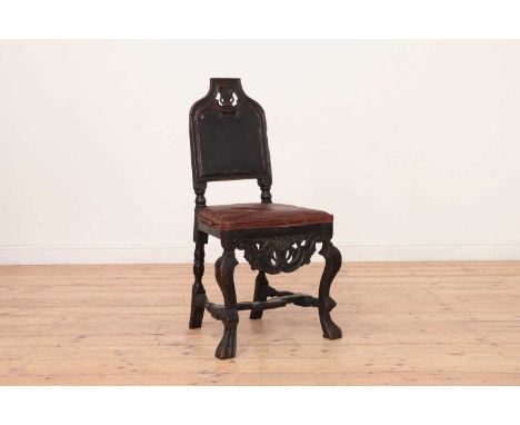 A Dutch ebonised walnut side chair,17th century, with a carved arched back, fabric panel and later seat, to a carved apron an