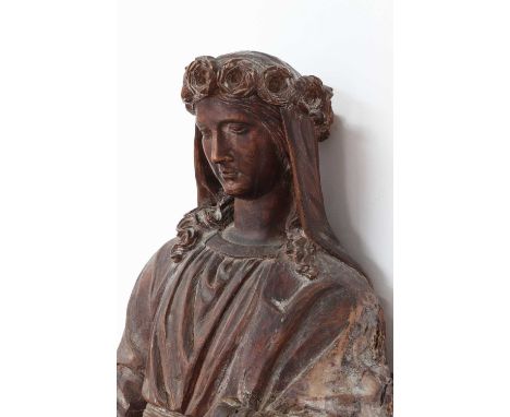 A Continental carved limewood figure of Saint Rose of Lima,17th century or earlier, the subject wearing a crown of roses and 