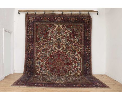 A Persian wool carpet,late 20th century, Iranian, Isfahan or Kashan, the cream field woven with a central floral medallion wi