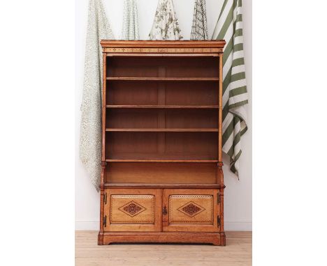 A Gothic Revival oak open bookcase, 19th century, in the manner of Charles Bevan, the moulded cornice with incised cross and 