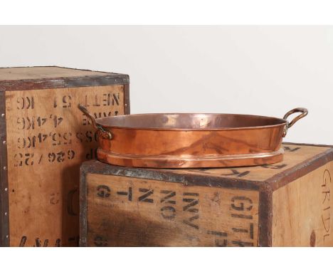 An oval copper pan,19th century, with a brass handle to either side, the front engraved with a baron's coronet over letter 'W