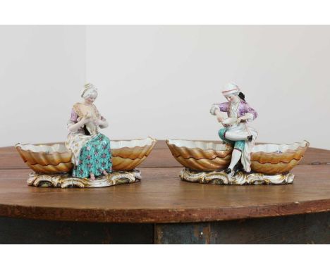A pair of Meissen porcelain figural double salts,19th century, the first centred with a woman plucking a goose, the second wi