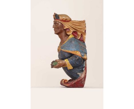 A carved wood ship's figurehead,late 19th century, polychrome painted, the Eastern figure holding grapes and wearing a star h