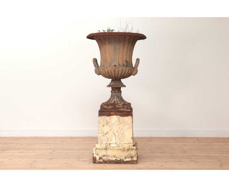 A cast iron urn and stand,19th century, the campana-shaped urn with two handles, on a square plinth,60cm diameter133cm high (