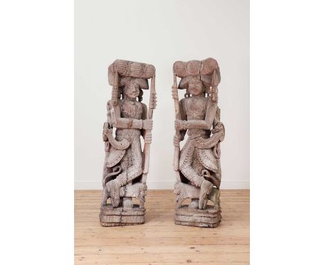 A pair of hardwood figural architectural fragments,early 20th century, Indian, each in the form of a man holding a spear,42cm
