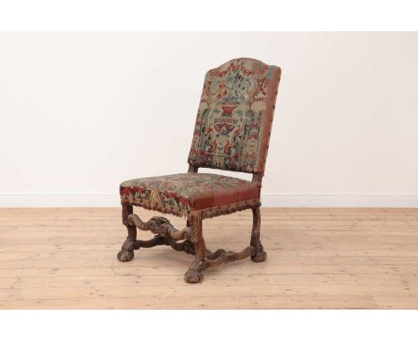 A carved walnut-framed side chair,18th/19th century, Continental, with tapestry upholstery, raised on foliate-detailed scroll