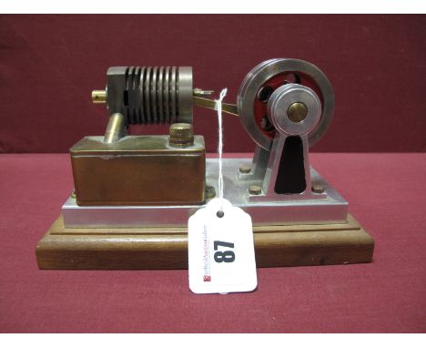 A Small Machined Hot Air Engine Double Flywheel 5cm Dia to Single Cylinder, attached to wooden plinth 18m x 10cm.