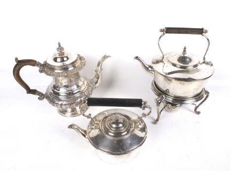 A silver plated copper tea pot and tow tea kettles. The round teapot on foot with a hinged cover with finial, part spiral flu