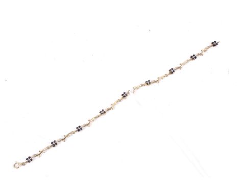 A 9ct gold black sapphire and diamond cluster bracelet. In the form of bud and scrolling branches with tiny diamonds and sapp