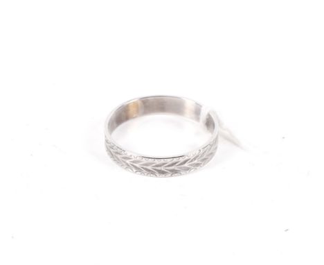 A modern 9ct white gold wedding band. Diamond cut with chevrons between stylised part flower-head borders, Birmingham convent