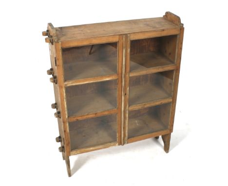 A Victorian pine floor standing cupboard. With two glazed doors opening to reveal three shelves, raised on bracket supports, 