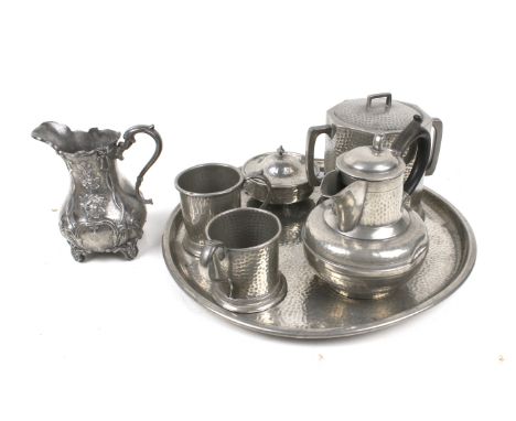 A vintage pewter tea service. Mostly of hammered form, including cups, a biscuit barrel and a lidded jug, etc. Max. H15cm
