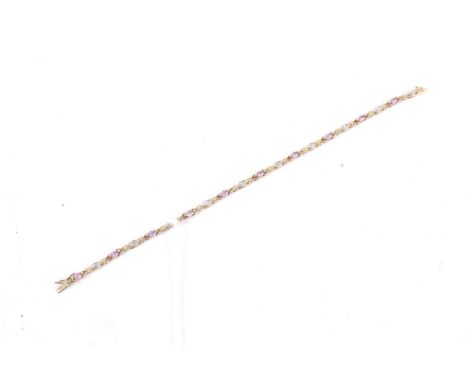 A modern 9ct gold, pink sapphire and diamond bracelet. In the form of alternate marquise shaped sapphires and tiny eight-cut 