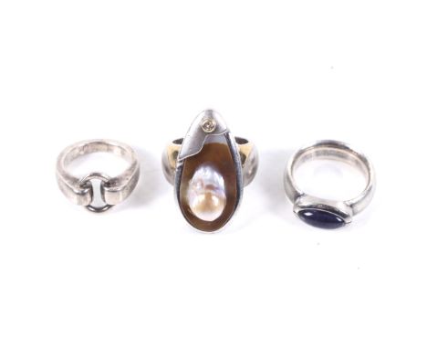 A group of three silver rings. One drop-shaped and rub-over set with a small round brilliant 'champagne' diamond and with gil