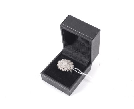 A modern silver and diamond 'snow flake' cluster ring. Set throughout with eight-cut and baguette diamonds, on a square secti