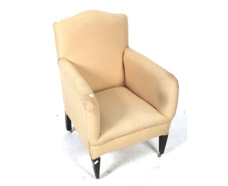 A 20th century armchair. Upholstered in light brown fabric, raised on ebonised tapered supports, on casters, H92cm