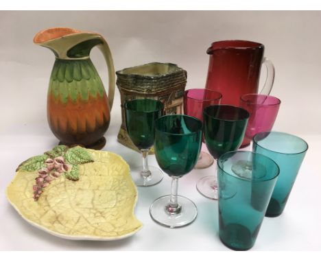 A cranberry glass jug, some coloured glasses, Carltonware dish plus two ceramic jugs comprising a Royal Doulton and a Myott e