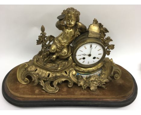 A French style ormolu mantle clock with porcelain panel and painted dial, on wooden base under glass dome.Base length approx 
