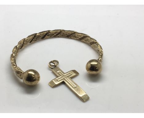 A 9ct gold torque bangle and a 9ct gold cross, approx 25.8g