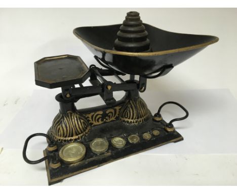A pair of vintage kitchen scales with weights.