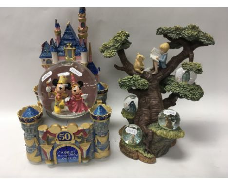 4 Walt Disney snow globes including a Disneyland 50th anniversary, a Winnie The Pooh 75th anniversary, Alice in Wonderland an