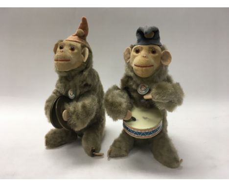 A pair of working West German clockwork chimpanzees; one playing drums, the other symbols.