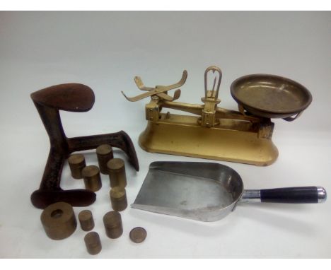 A set of beam balance scales with a set of weights, a shoe last and a coal shovel.