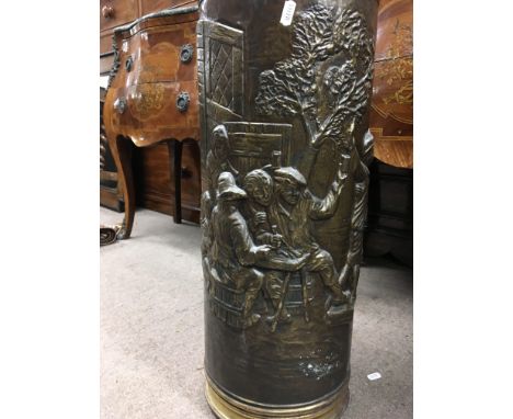 A brass cylinder stick stand with figures making merry