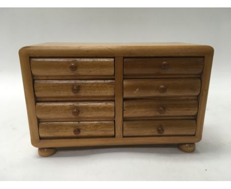 A miniature chest of drawers with a collection of Edwardian & Victorian button sets.