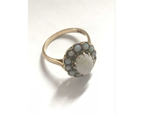 A Ladies 9ct yellow opal ring the central opal flanked by conforming smaller opals.