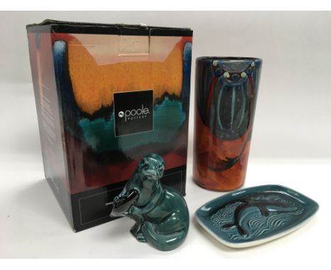 Three Poole pottery items comprising a boxed Himalayan Poppy vase, an otter figure and a dish depicting a dolphin (3).