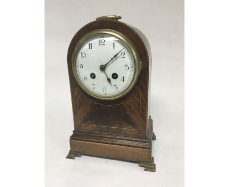 An Edwardian inlaid Mahogany clock, with a convex enamel dial brass fittings and embellishments. Fitted with a French movemen