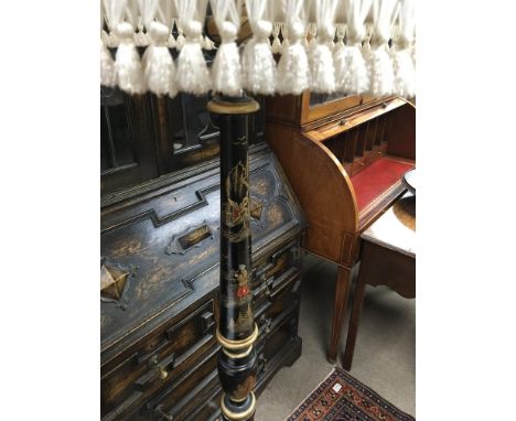 A stand lamp with cream shade turned collom with orential influences