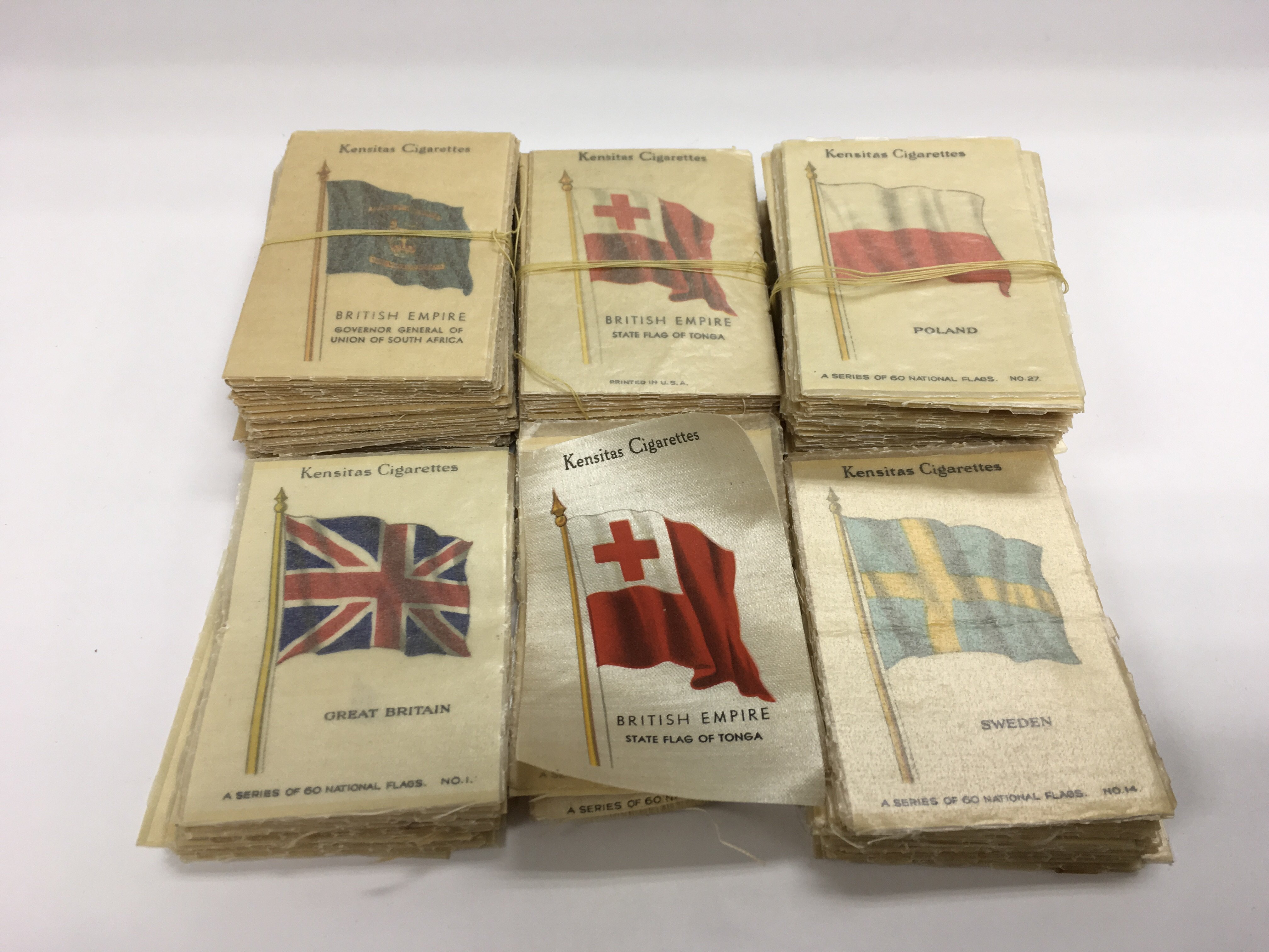 A collection of Kensitas silk cigarette cards depicting flags of the world.